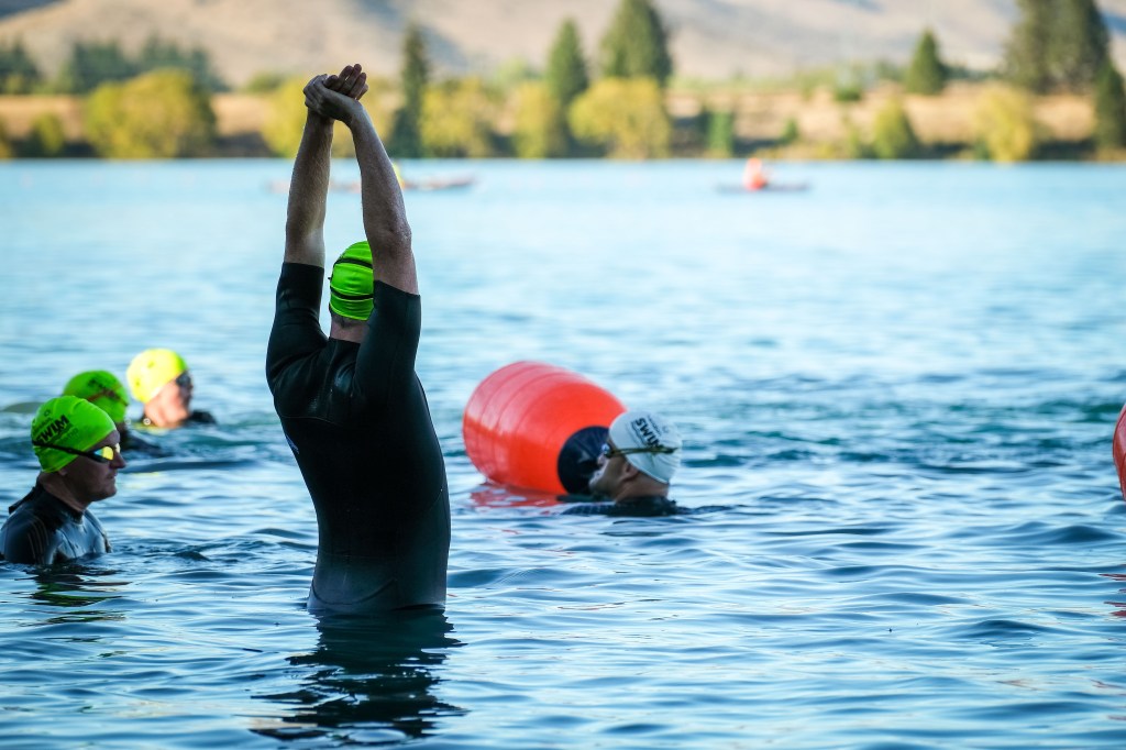 swimmers warming up in the lake before the race, figure in the middle is stretching.